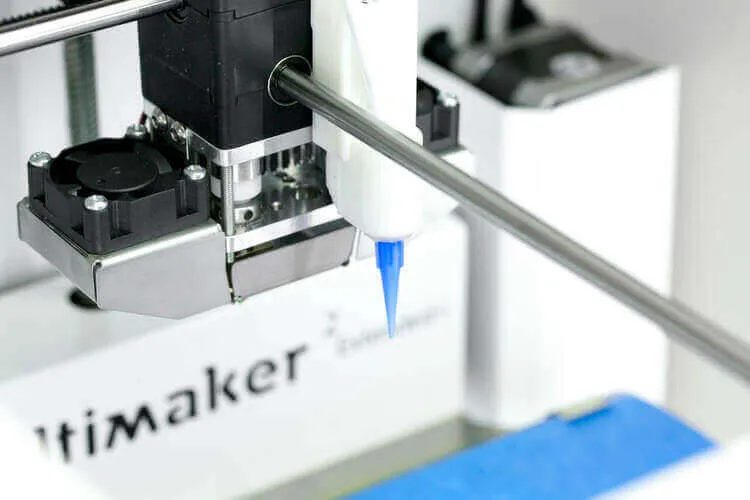 Paste-dispensing nozzle mounted beside the print head of an Ultimaker printer.
