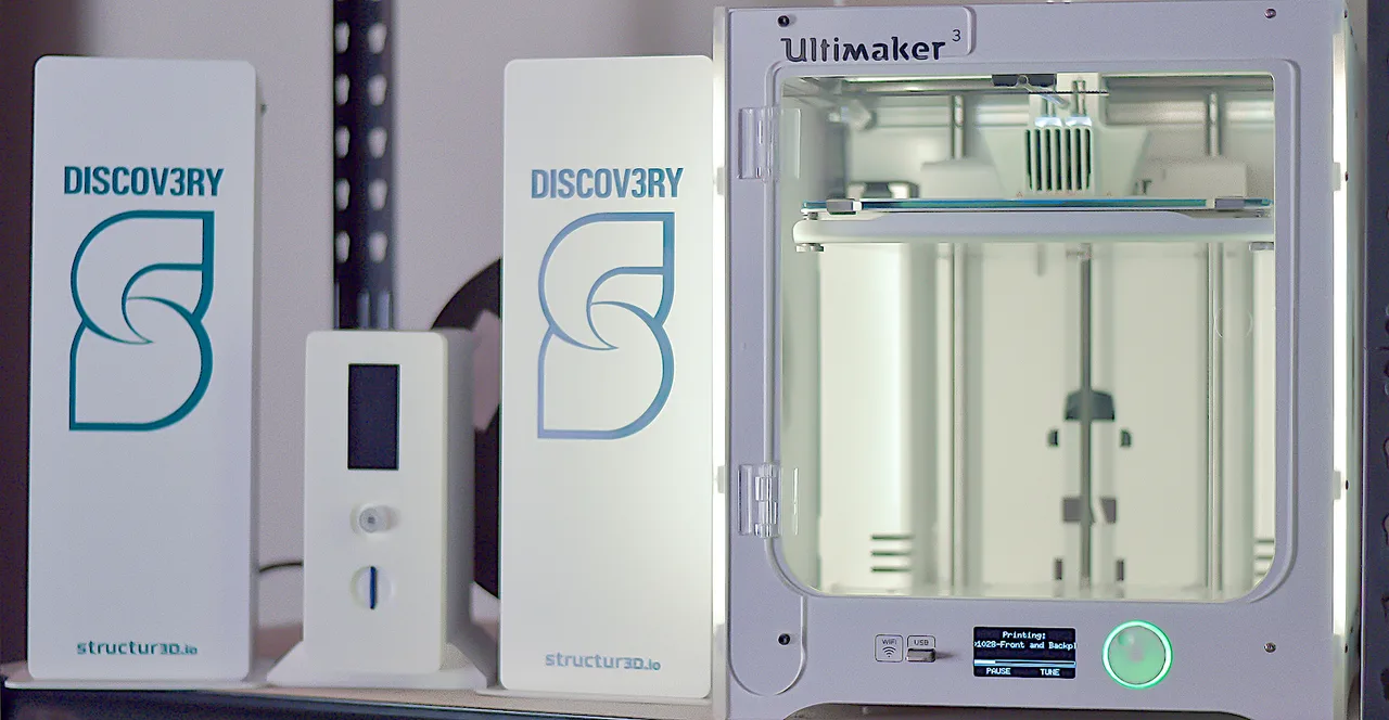 Discov3ry-branded extrusion hardware beside an Ultimaker 3 printer.